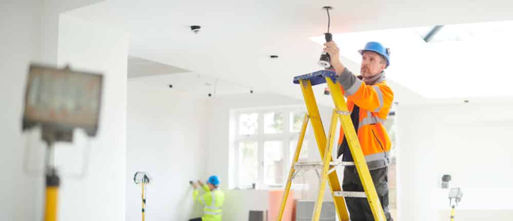 electrician installing overhead lighting