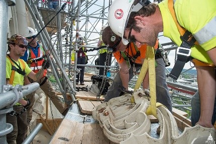 workers lifting object with crane